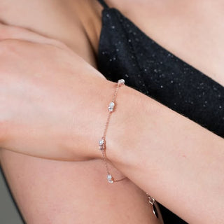 Rose gold bracelet on a person's wrist with a blurred background
