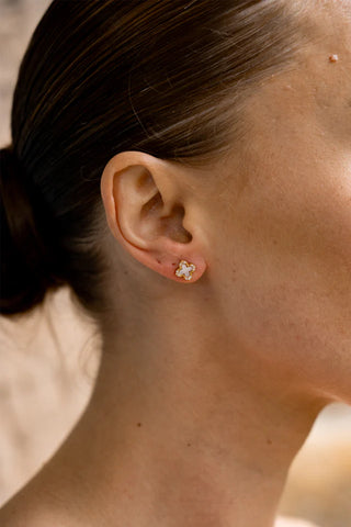 Close-up of a person wearing a floral earring with a blurred background