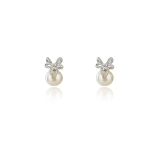 A pair of silver stud earrings featuring a small bow design set with clear stones and a single round white pearl below each bow, shown on a clean white background with soft reflections.
