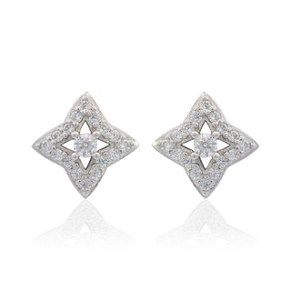 A pair of silver-toned stud earrings with a four-pointed star design, featuring a central clear gemstone surrounded by smaller pavé-set clear stones, shown on a white background with a soft reflection below.