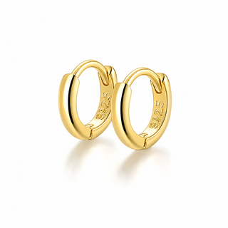 A pair of polished yellow gold huggie hoop earrings with a 14k gold-plated inner band, shown on a clean white background with a soft reflection.
