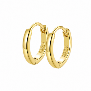 A pair of polished yellow gold huggie hoop earrings with a 925 sterling silver hallmark engraved inside the hoops, set against a plain white background.