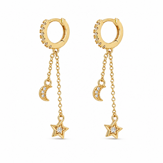 A pair of gold dangle earrings featuring a huggie hoop adorned with small clear crystals, hanging chains with crescent moon charms, and star-shaped charms, shown on a plain white background.