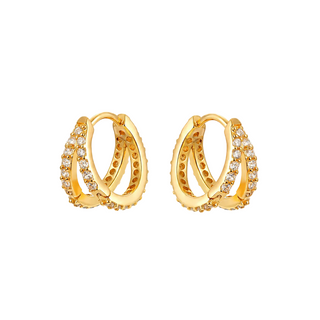 A pair of gold huggie hoop earrings adorned with rows of small clear pavé-set stones, shown on a light gray background.