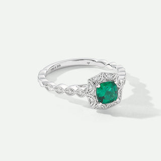 Silver ring with a green gemstone on a white background