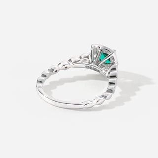Silver ring with a green gemstone on a white background