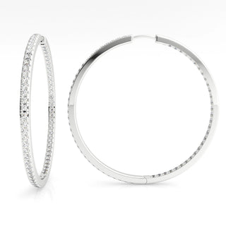 Pair of silver hoop earrings with clear gemstones on a white background