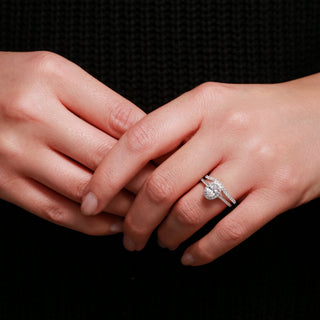 Close-up of hands with a diamond ring on a black background