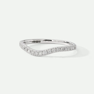 Silver ring with small diamonds on a light gray background