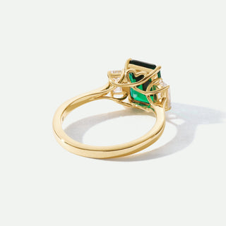 Gold ring with a green gemstone on a white background