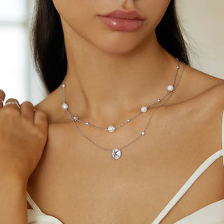 Close-up of a woman wearing a delicate silver necklace with pearls.