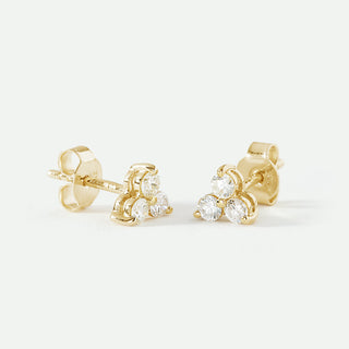 Gold earrings with clear gemstones on a white background