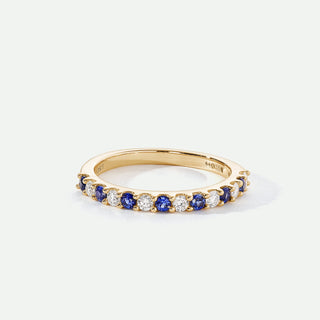 Gold ring with blue and white gemstones on a white background