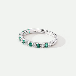 Silver ring with green gemstones on a white background