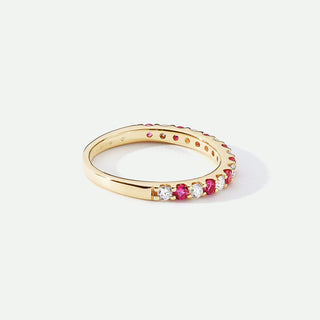 Gold ring with embedded gemstones on a white background