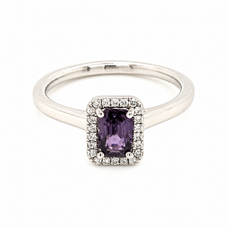 A platinum ring featuring a rectangular purple sapphire gemstone surrounded by a halo of small clear stones, set on a polished silver band against a white background.
