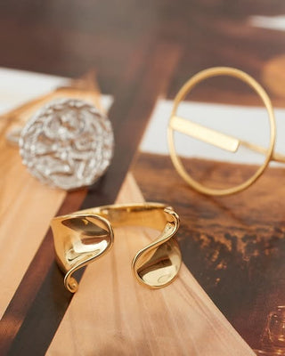 Gold rings on a wooden surface with a blurred background