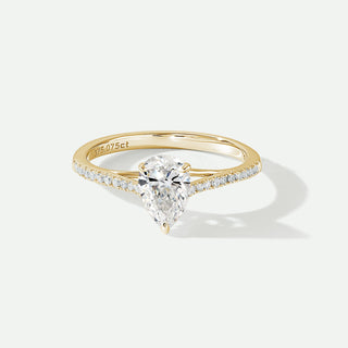 Gold ring with a pear-shaped diamond on a white background
