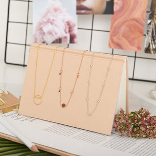 Set of necklaces on a display card with a decorative background