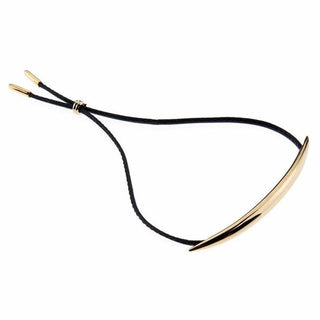 Gold crescent-shaped bracelet with black cord on a white background
