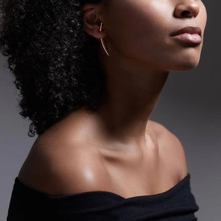 Close-up of a woman's neck and shoulders with a dark background