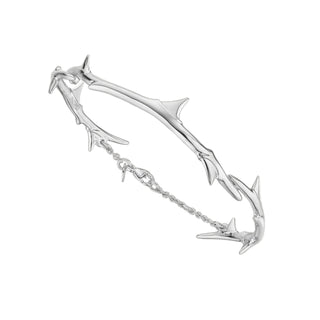 Silver bracelet with unique branch design on a light gray background