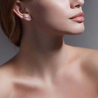 Close-up of a woman's neck and shoulder with a neutral background