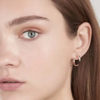 Close-up of a person wearing a silver hoop earring.