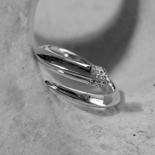 Silver ring with a diamond on a gray surface