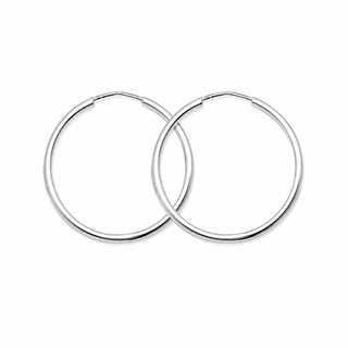 A pair of polished silver hoop earrings overlapping on a plain white background.