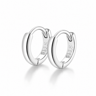 A pair of polished sterling silver huggie hoop earrings with '925' silver purity stamped on the inside, displayed on a clean white background with a soft reflection.
