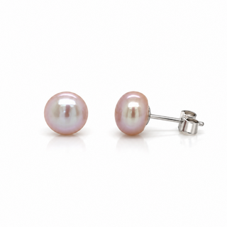 A pair of oval freshwater pearl stud earrings with a soft pink luster, set in silver-tone posts with butterfly backings, shown on a clean white background.