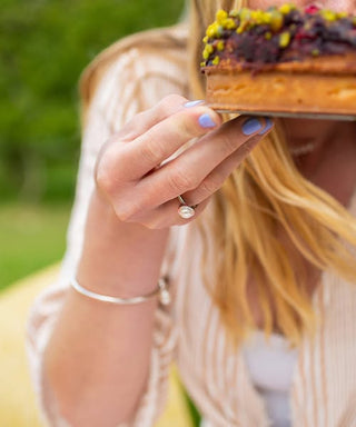 Person holding a colorful cake with a blurred background