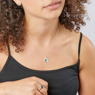 Woman wearing a necklace with a pendant, close-up on neck and chest.