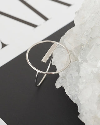 Silver ring on a black and white background with a natural stone