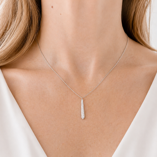 Silver necklace with a pendant on a person wearing a white top
