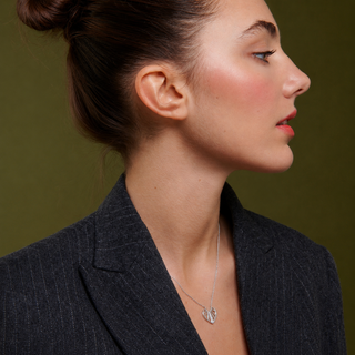 Woman wearing a dark blazer with a green background