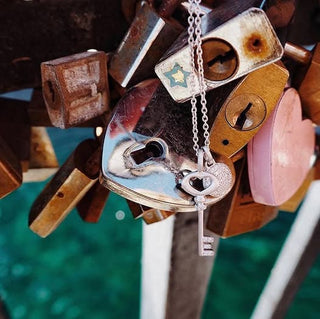 Lock with heart and key design on a metal fence with padlocks