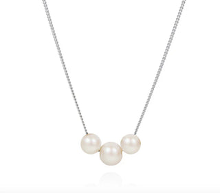 Pearl necklace with three pearls on a white background