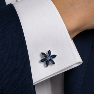 Cufflink on a white cuff against a navy suit background