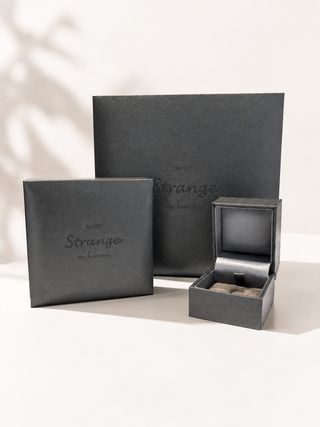 Gray jewelry box with 'Strange the Jewellers' branding on a light background