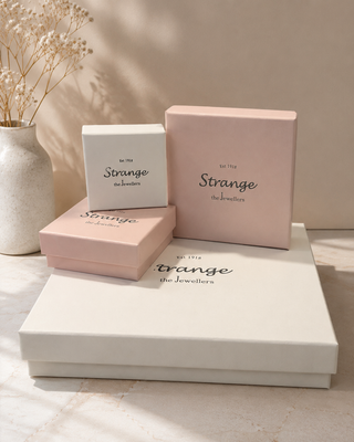 Set of jewelry boxes with 'Strange' branding on a neutral background
