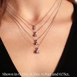 Necklace with diamond pendants on a person's neck, shown in different carat weights.