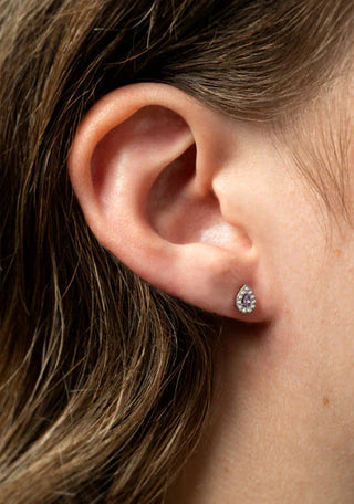Close-up of an ear wearing a purple stud earring.