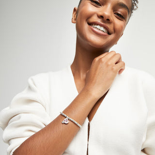 Woman wearing a stretchy heart beaded bracelet with a neutral background