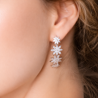 Close-up of a woman wearing silver floral earrings.