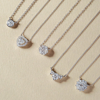 Silver necklaces with various pendants on a beige background