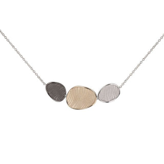 Necklace with three circular pendants in different metals on a white background