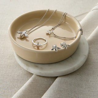 honey bee jewellery in a beige bowl