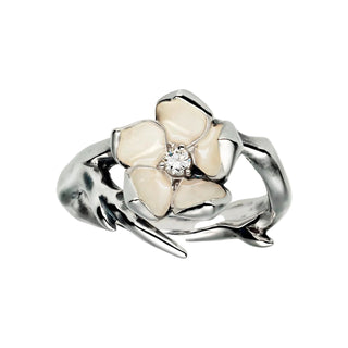 Silver ring with a white flower design and central diamond on a light gray background